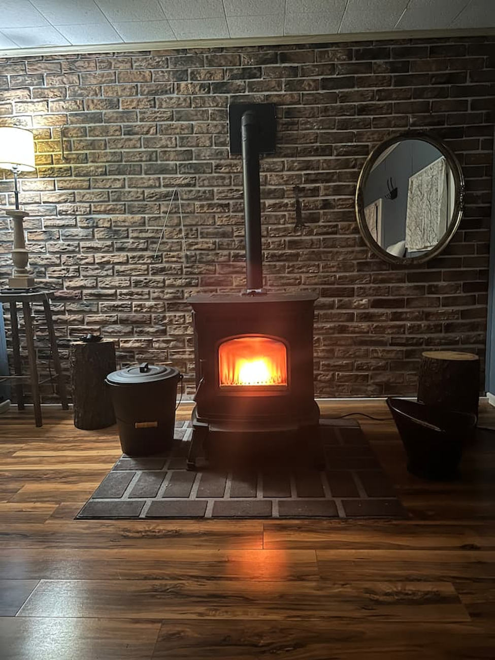 Wood stove glowing against a brick wall
