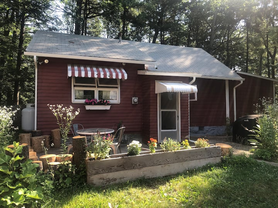 StarryPines Cottage exterior with striped awnings and garden
