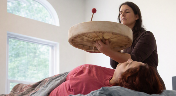 Alicia offering a reiki sound healing session with a hand drum