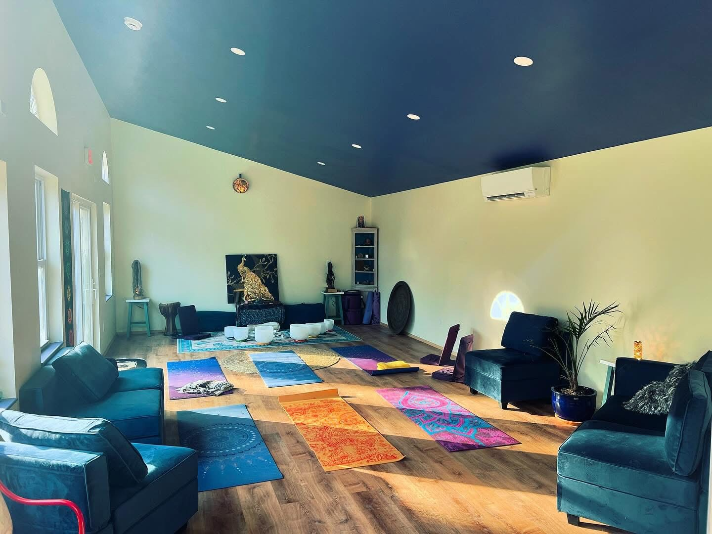 StarryPines Studio interior with yoga mats, natural light, and a deep blue ceiling